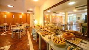 A buffet area with various food items and a large mirror reflecting the room. - Hotel Torre di Pratolungo (Rome)