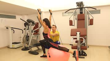 A gym with exercise equipment, including a rowing machine and a stationary bike.