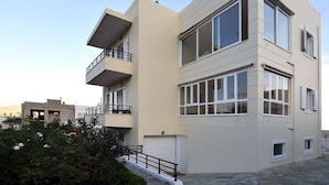Un immeuble moderne à plusieurs étages, doté de balcons, de grandes fenêtres et d’un garage.