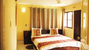 A bedroom with a bed, curtains, a ceiling fan, and a door. - Pekan Hotel (Accra)