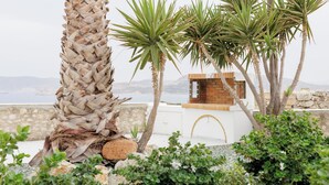 Ein Küstenhaus mit weißer Fassade, einem Kamin aus Ziegelsteinen und Blick aufs Meer.