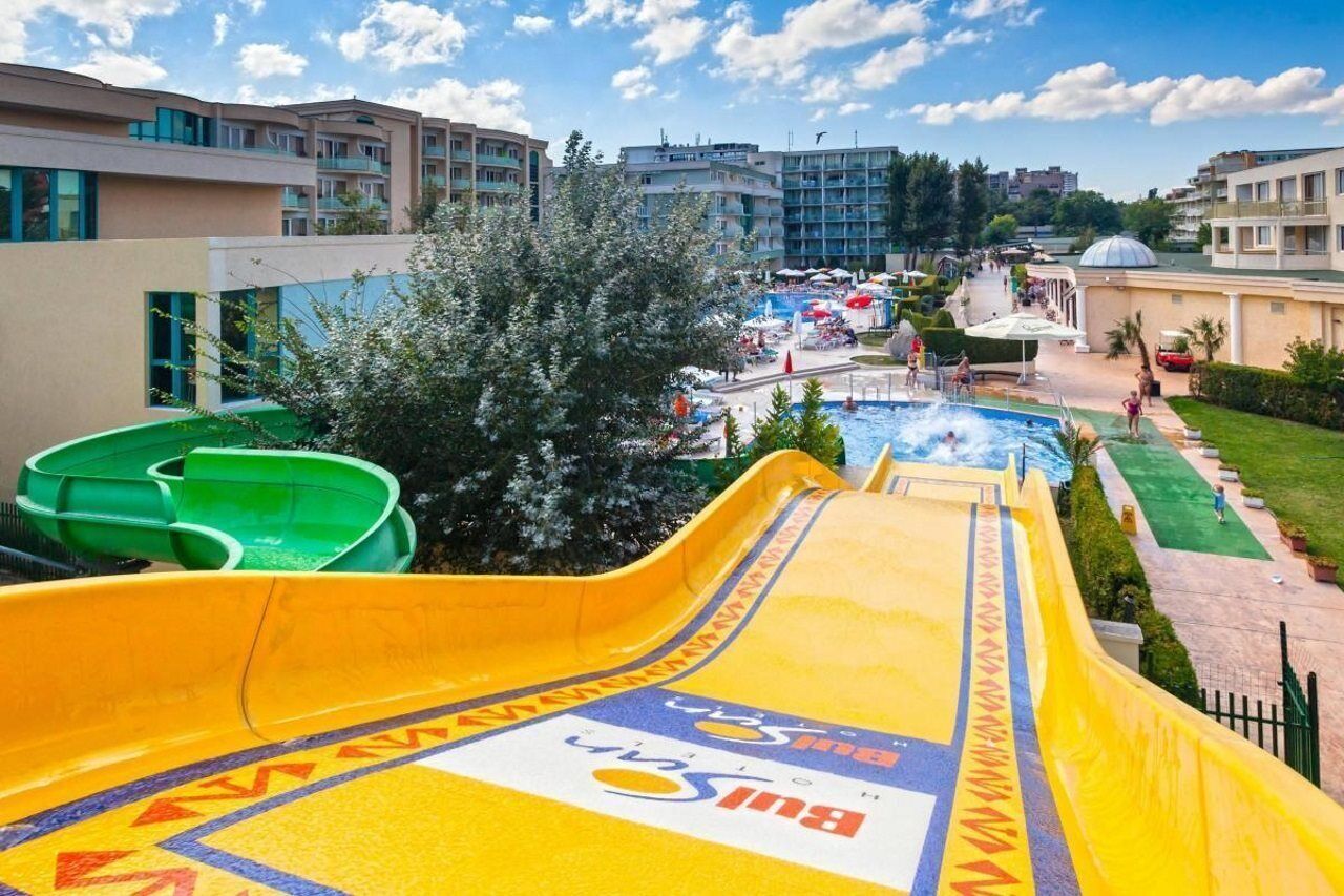 A water park with slides, a pool, and a view of surrounding buildings.