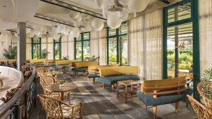 A spacious indoor area with multiple seating arrangements, including sofas and chairs, and large windows providing natural light. - DAS Club Hotel Sunny Beach (Nessebar)