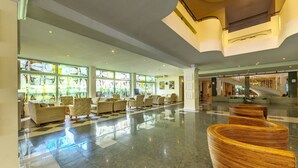 A spacious lobby with a checkered floor, wicker furniture, and large windows with artwork. - DAS Club Hotel Sunny Beach (Nessebar)