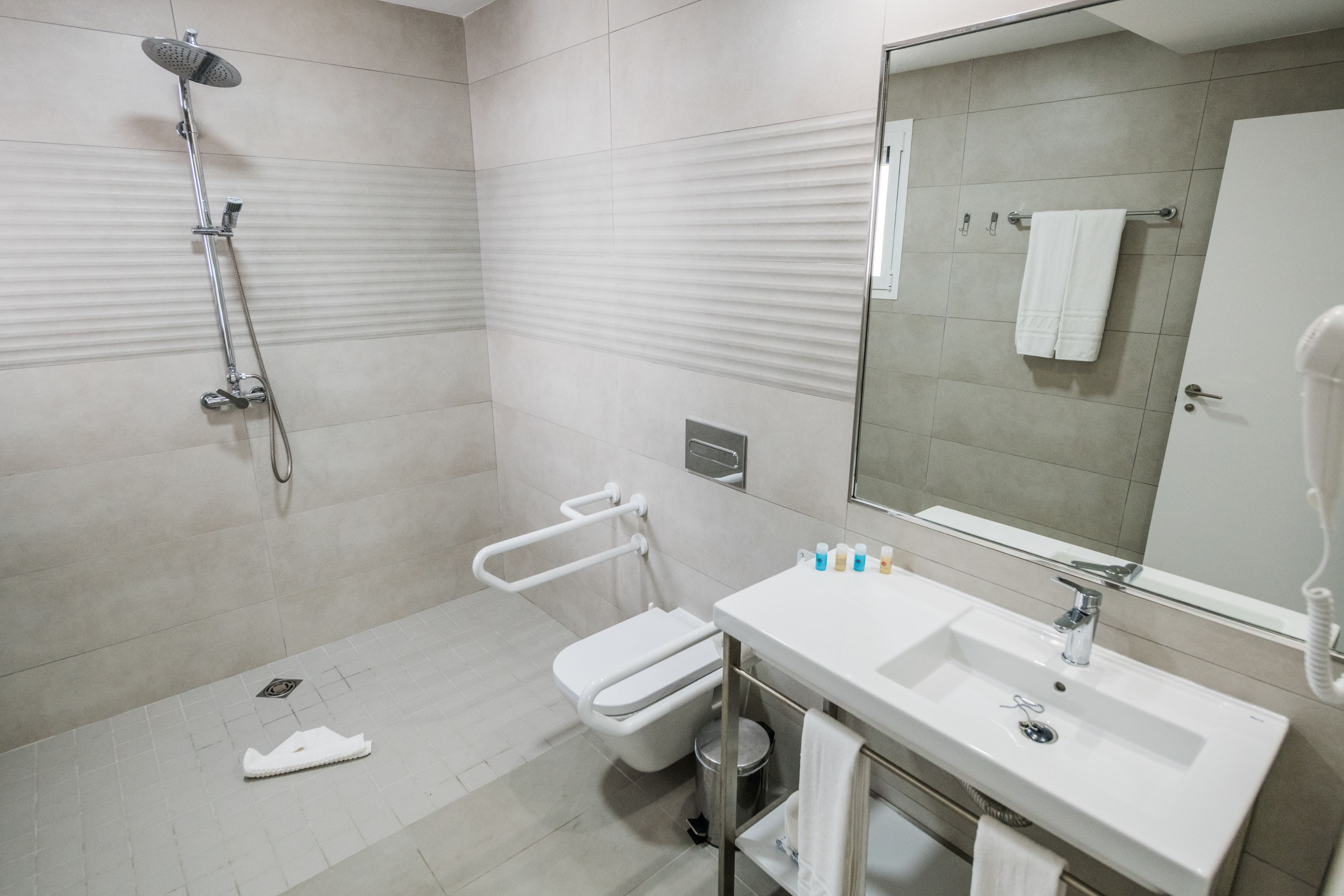 A modern bathroom with a shower, toilet, and sink.