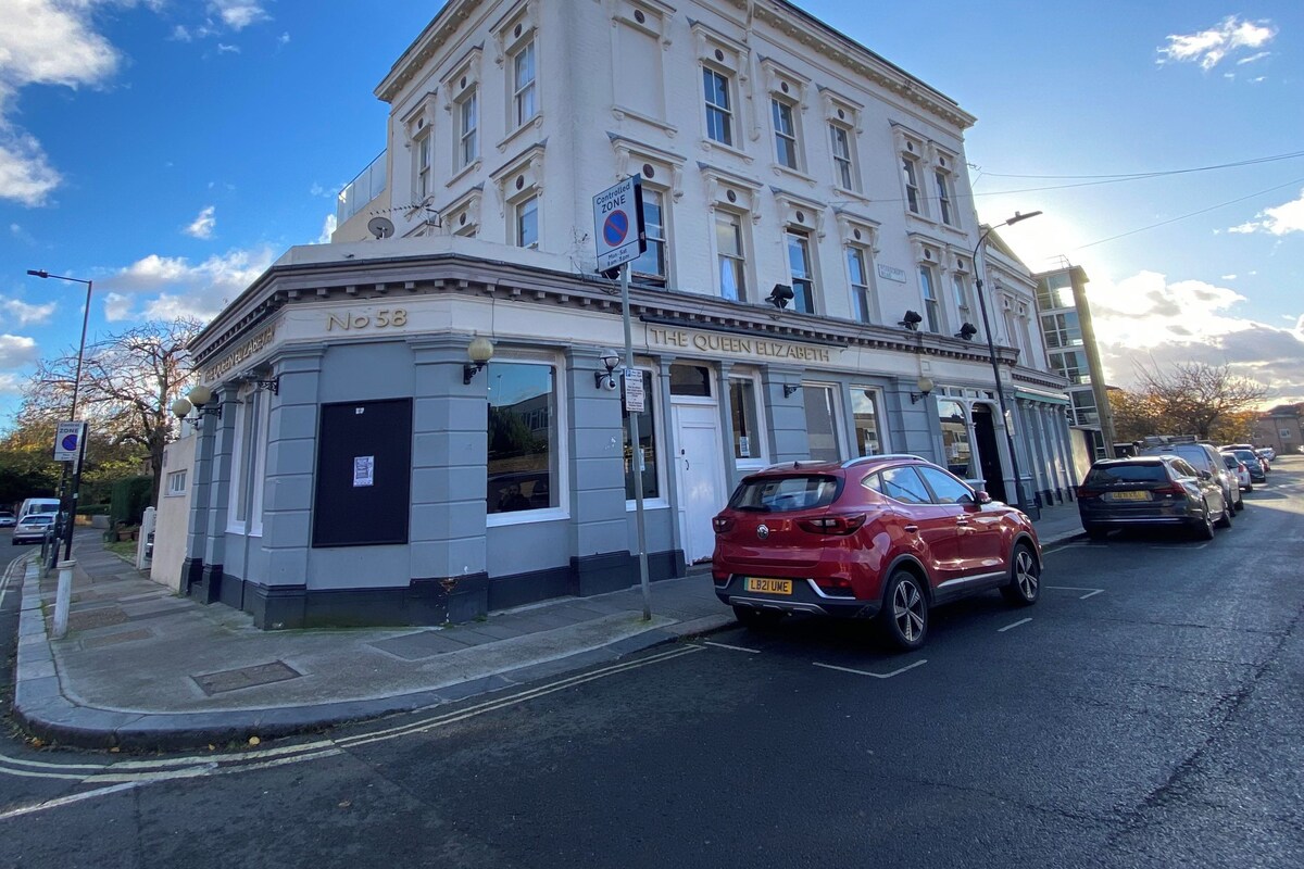 A historic building with a sign reading 'Controlled Zone' and a red car parked in front.