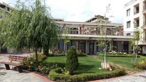 A courtyard with a central lawn, surrounded by buildings with balconies.