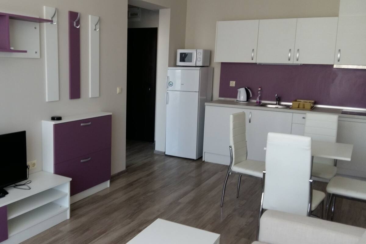 A compact living space with a kitchenette, a dining area, and a seating area.
