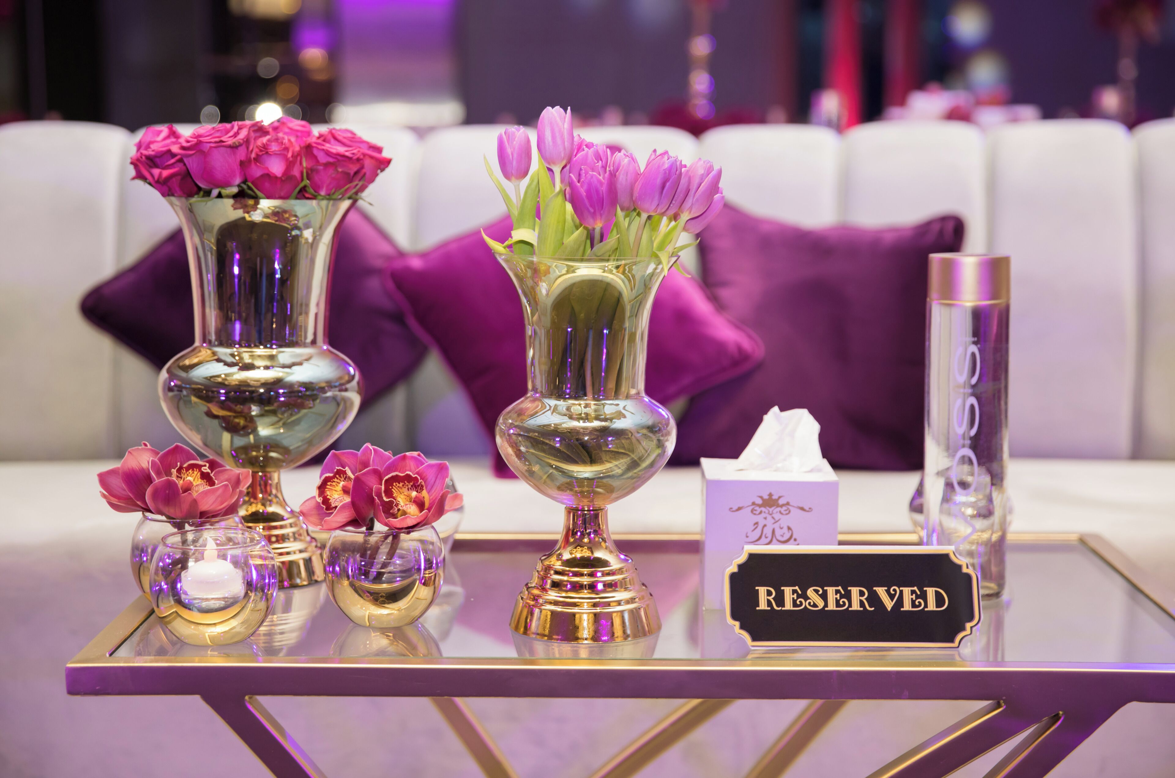 Une table avec des vases de fleurs, une boîte de mouchoirs et une pancarte indiquant « RESERVÉ ».
