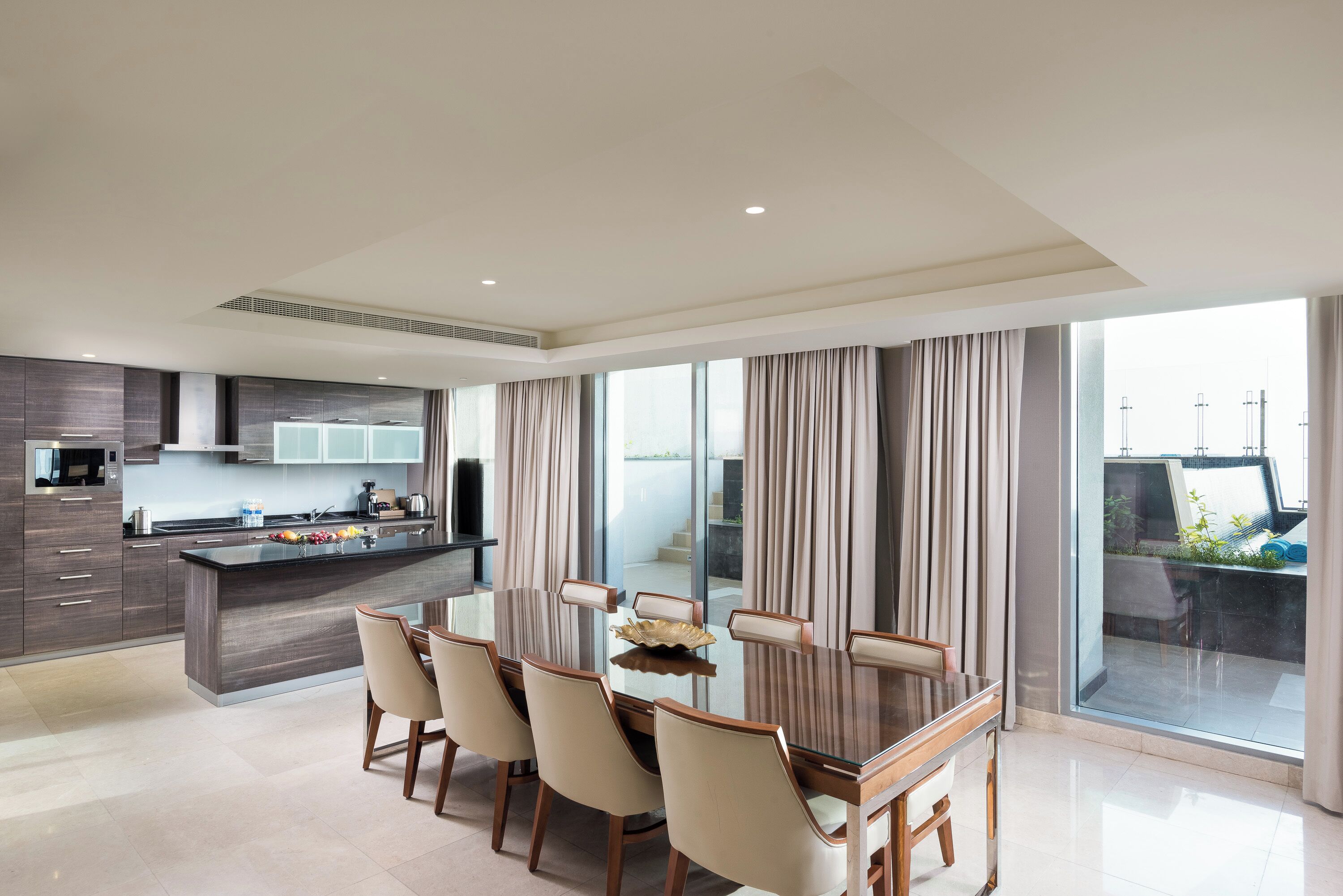 Una cocina moderna con zona de comedor, ventanas amplias y vistas al exterior.
