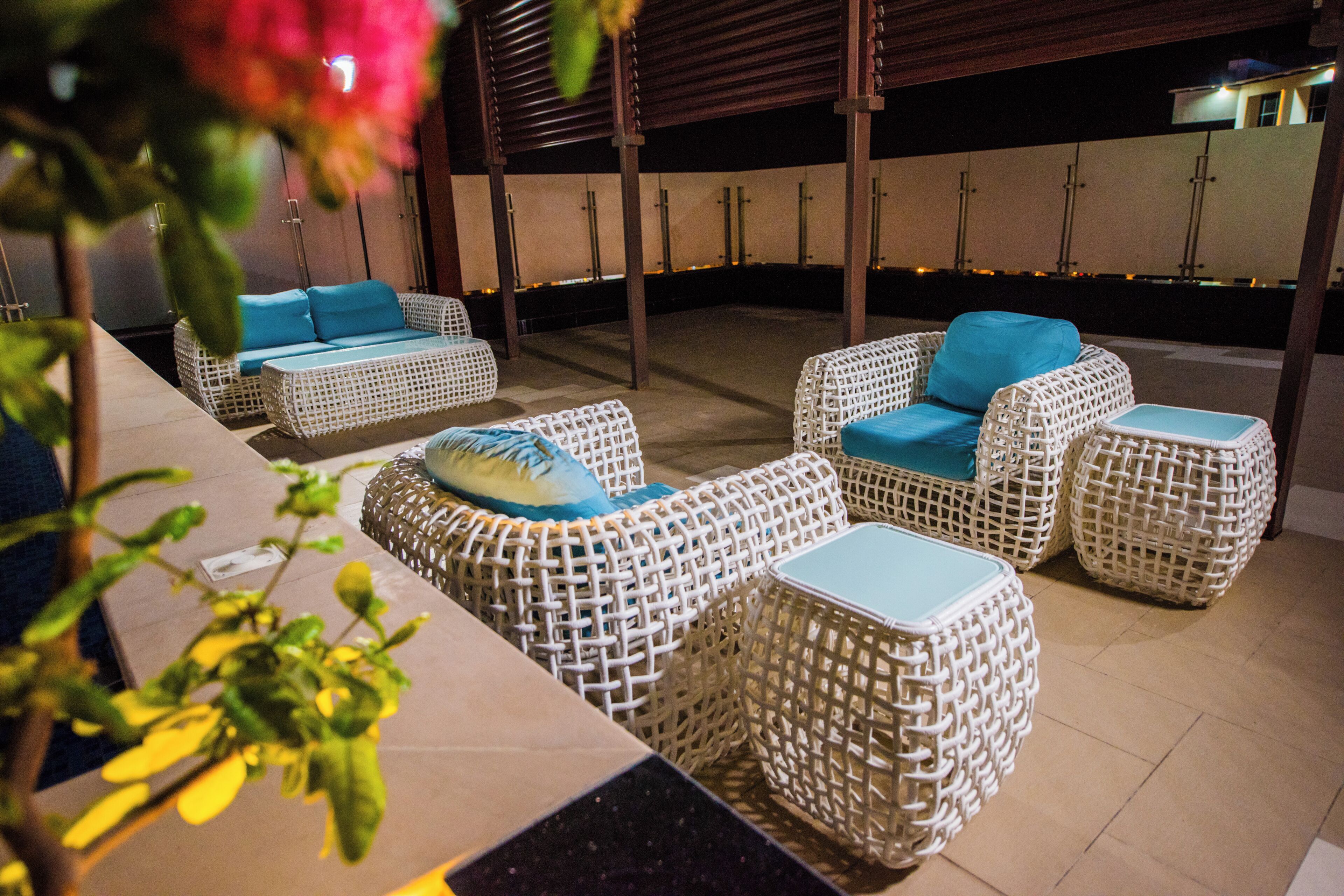An outdoor seating area with wicker furniture and cushions.