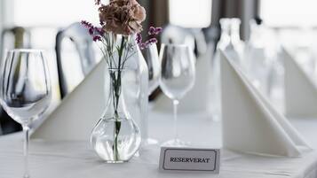 Ein Tisch mit einer Blumenvase, einem Weinglas und einem 'RESERVAT'-Schild.