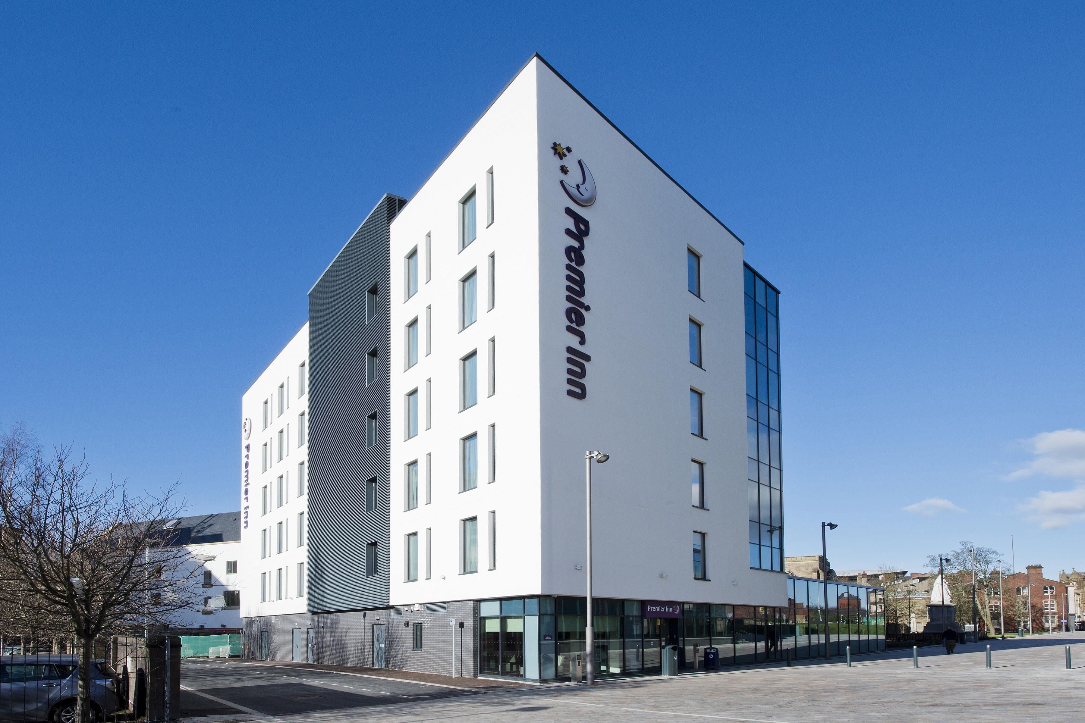 A modern building with a prominent logo, large windows, and a flat roof.
