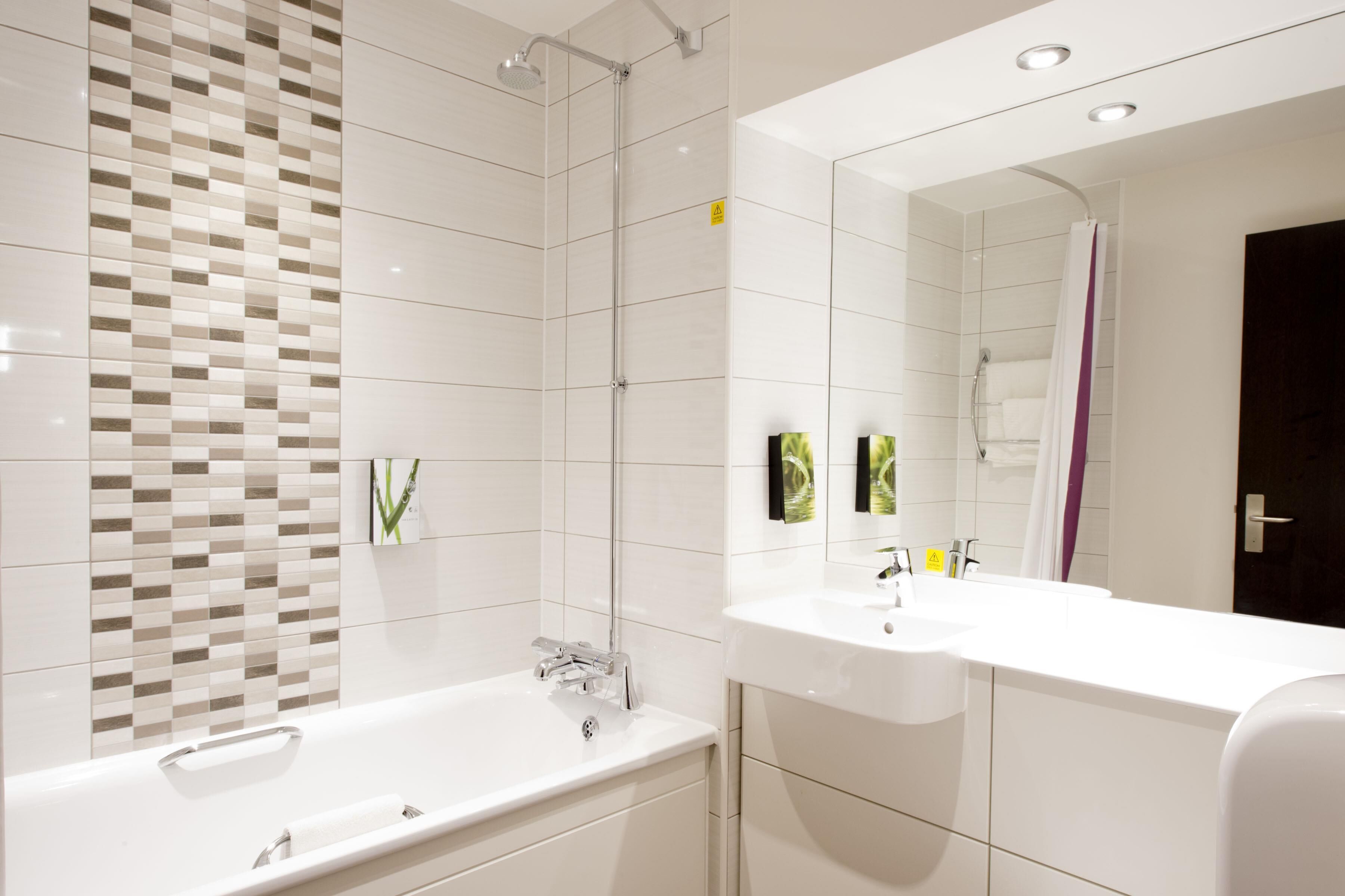 A modern bathroom with a shower, a bathtub, and a vanity with a mirror.
