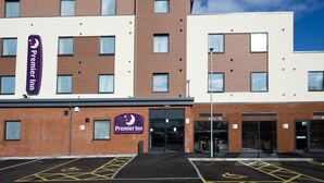 A Premier Inn hotel with a modern design, featuring a brick facade, multiple windows, and a parking area with disabled parking spaces. - Premier Inn Honiton (Honiton)