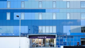 A modern hotel entrance with a prominent 'Premier Inn' sign, glass doors, and a clear view of the interior through the windows. - Premier Inn London Archway (London)