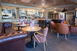A bar area with leather seating, a counter with a menu, and a 'Beefeater' sign. - Premier Inn London Uxbridge (Uxbridge)