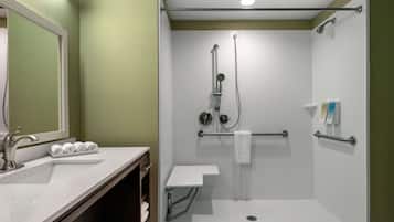 A bathroom with a shower, a sink, and a mirror.
