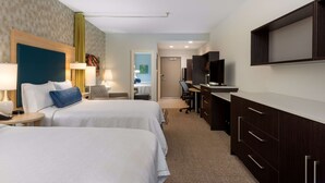 Een hotelkamer met twee bedden, een bureau, een televisie en een kledingkast.