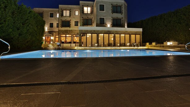 A modern hotel with a swimming pool, multiple floors, and a well-lit facade. - Marina Residence Boutique hotel (Varna)