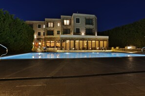 A modern hotel with a swimming pool, multiple floors, and a well-lit facade. - Marina Residence Boutique hotel (Varna)