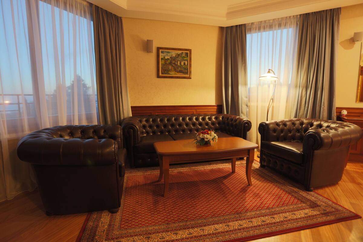 Una habitación con un sofá de cuero, un sillón de cuero y una mesa de centro de madera.
