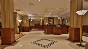 A spacious lobby with a central reception desk, high ceilings, and polished tile flooring. - Marina Residence Boutique hotel (Varna)
