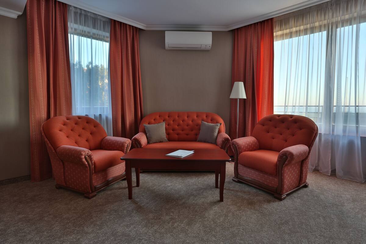 Una habitación con un sofá rojo, una mesa de centro de madera y una lámpara.