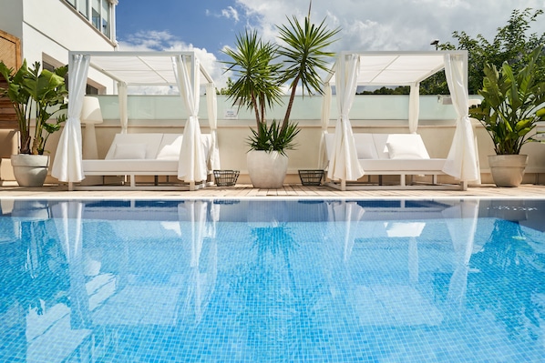 Piscine extérieure, parasols de plage, chaises longues