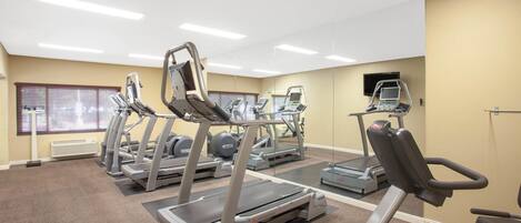 A gym with treadmills, elliptical machines, and a stationary bike.