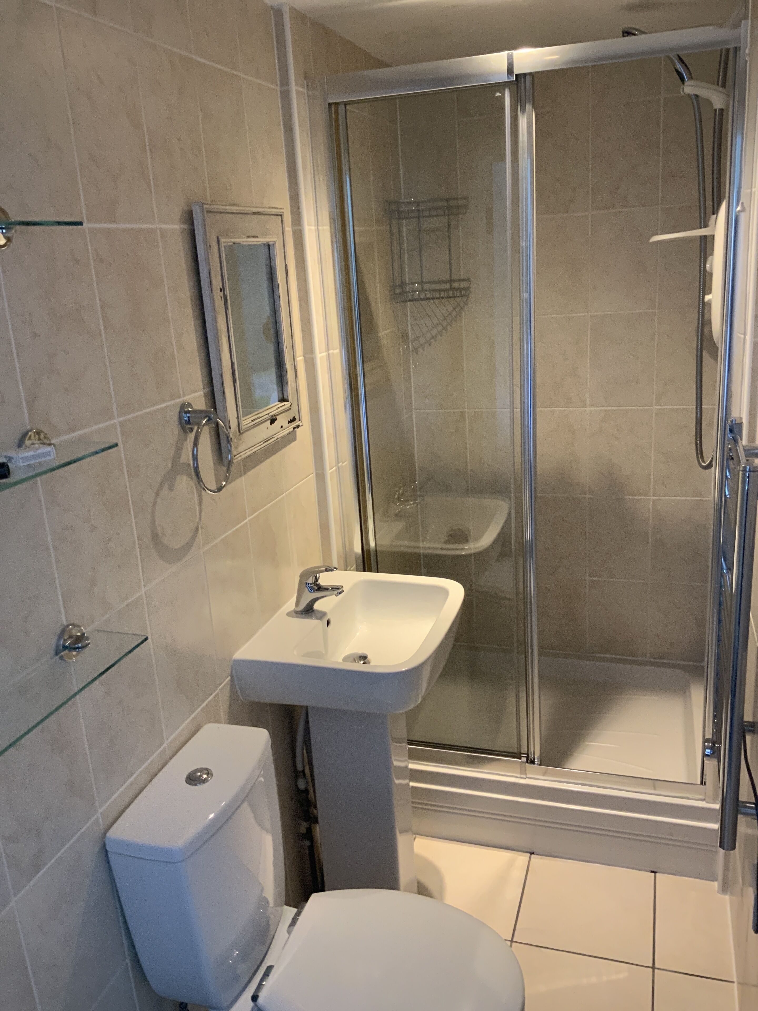 Ein Badezimmer mit Duschkabine, Standwaschbecken und Toilette.