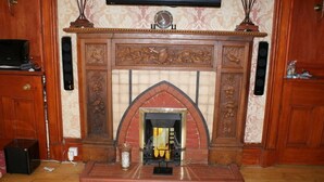Una chimenea con intrincados trabajos en madera y repisas ornamentales.