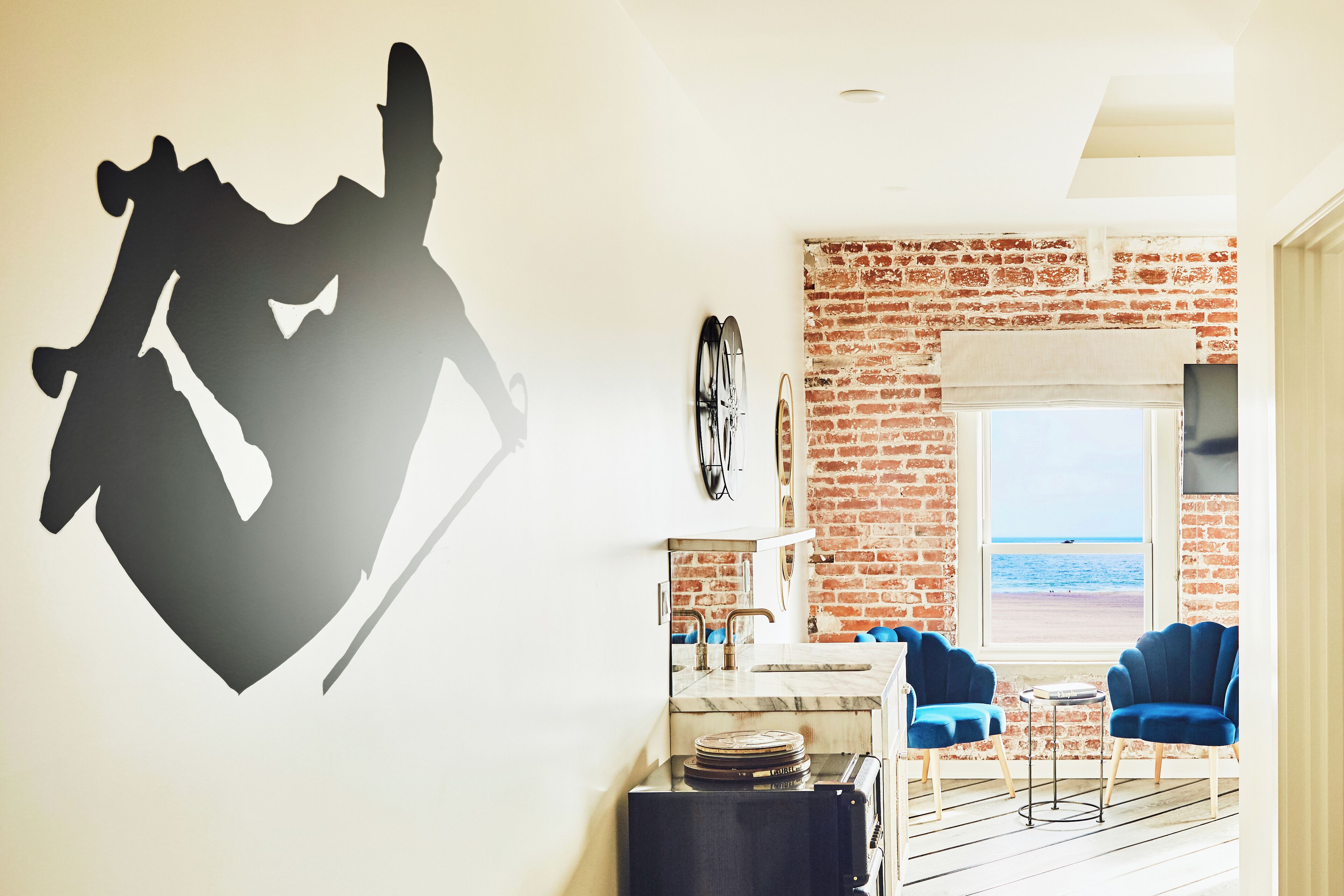A modern kitchen with a brick wall, a large window, and a view of the beach.