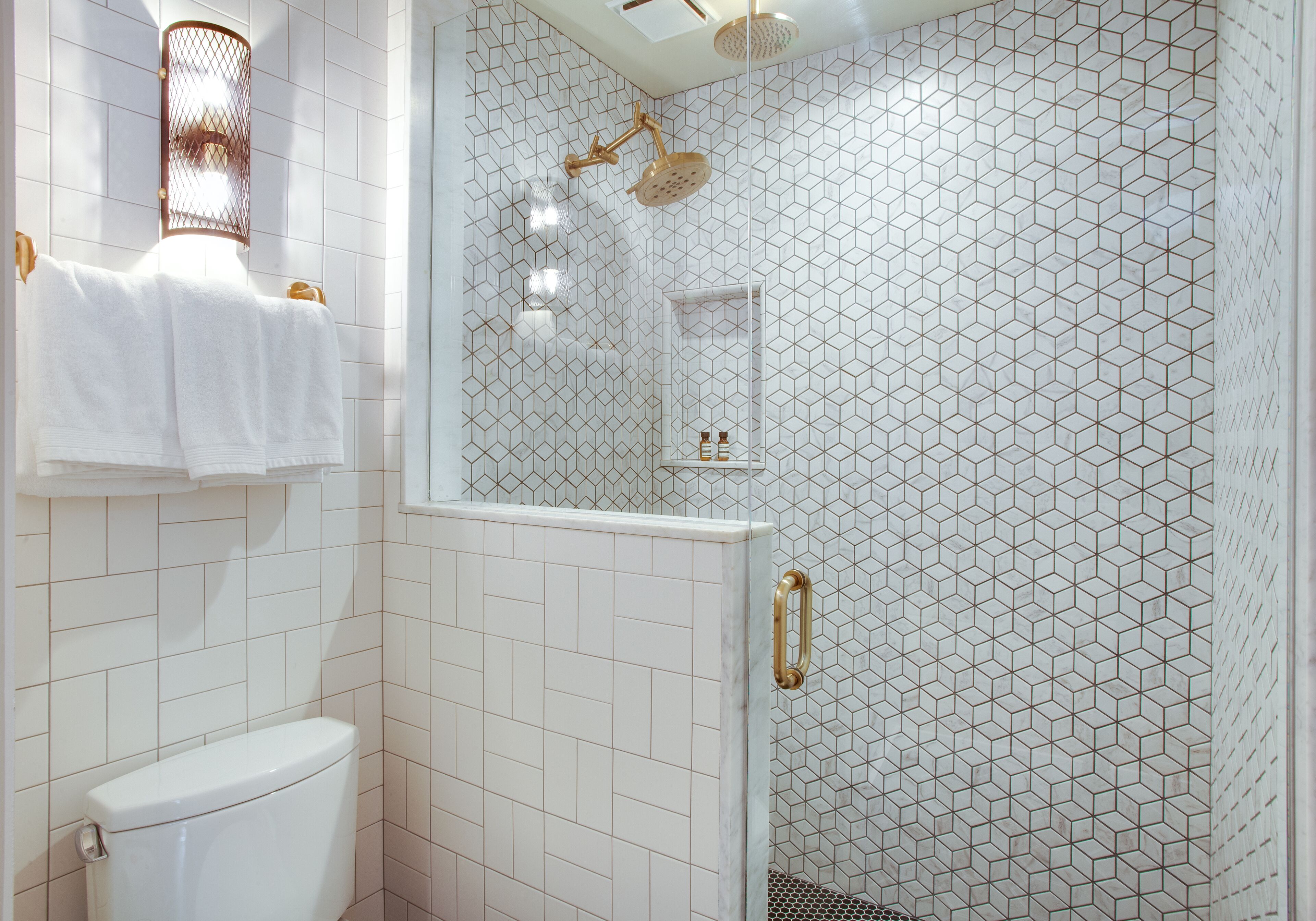 Ein Badezimmer mit Toilette, einer Duschkabine mit Glastür und einem Handtuchhalter.