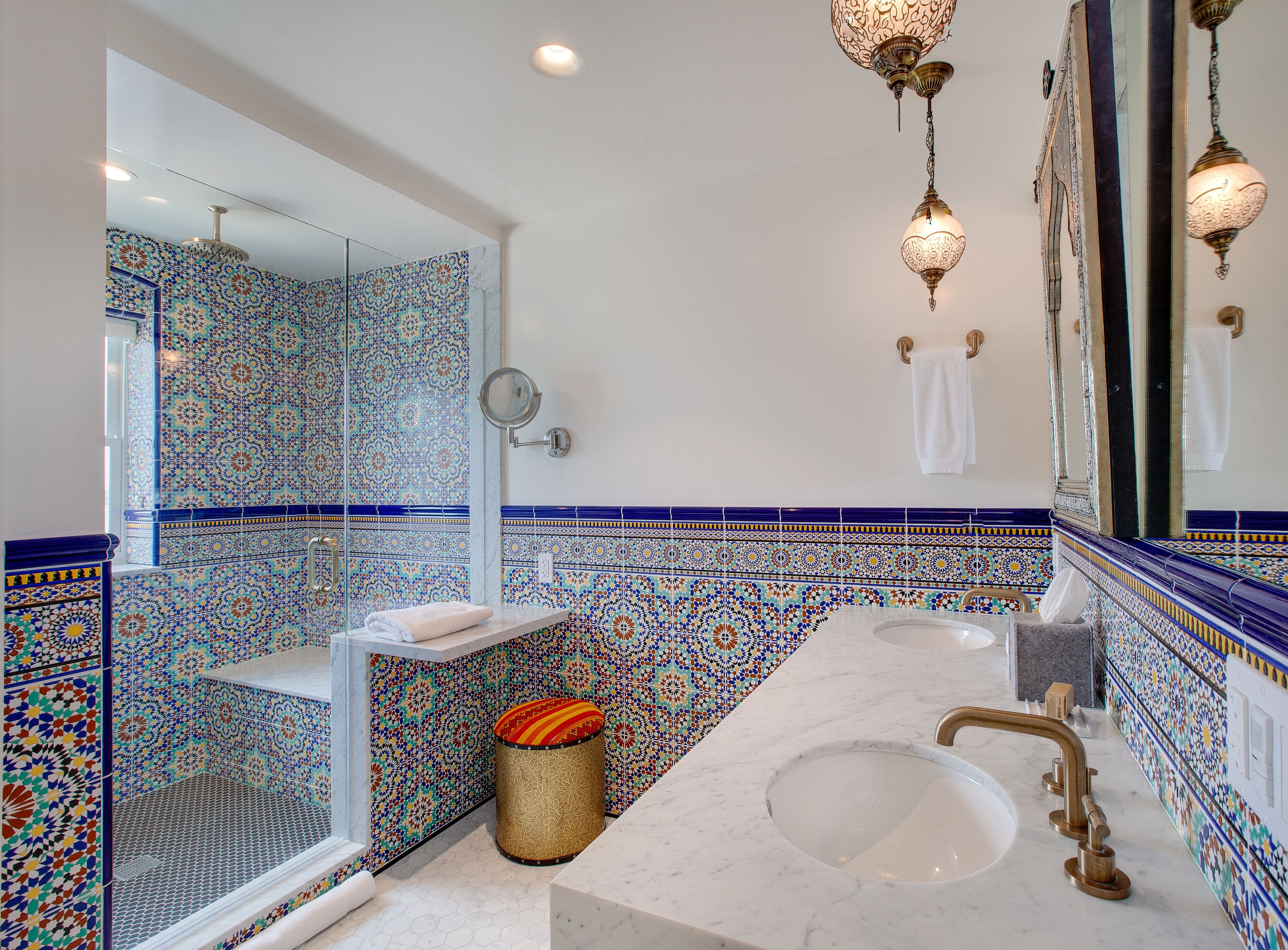 A bathroom with a large mirror, two sinks, and a toilet.