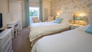 A bedroom with two beds, a desk, a chair, and a television. - Craig Y Glyn (Pwllheli)