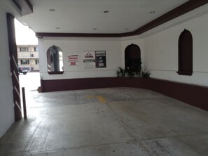 Amplio espacio interior con piso de concreto, paredes blancas y detalles de madera. Se observan dos ventanas arqueadas y un espejo grande en la pared.