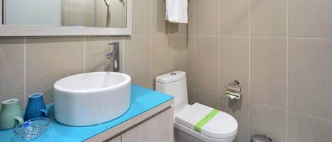 A bathroom with a sink, toilet, and shower.