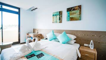 Une chambre d’hôtel avec un lit, une table de chevet, une chaise et des œuvres d’art accrochées au mur.