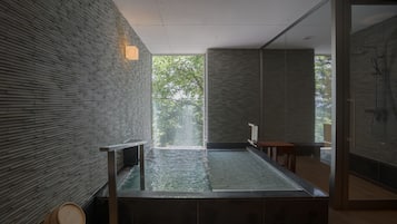 Relax in a serene spa room with a large hot tub and tranquil views.