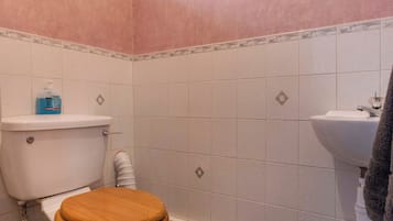 Ein Badezimmer mit Toilette, Waschbecken und Fliesenboden.