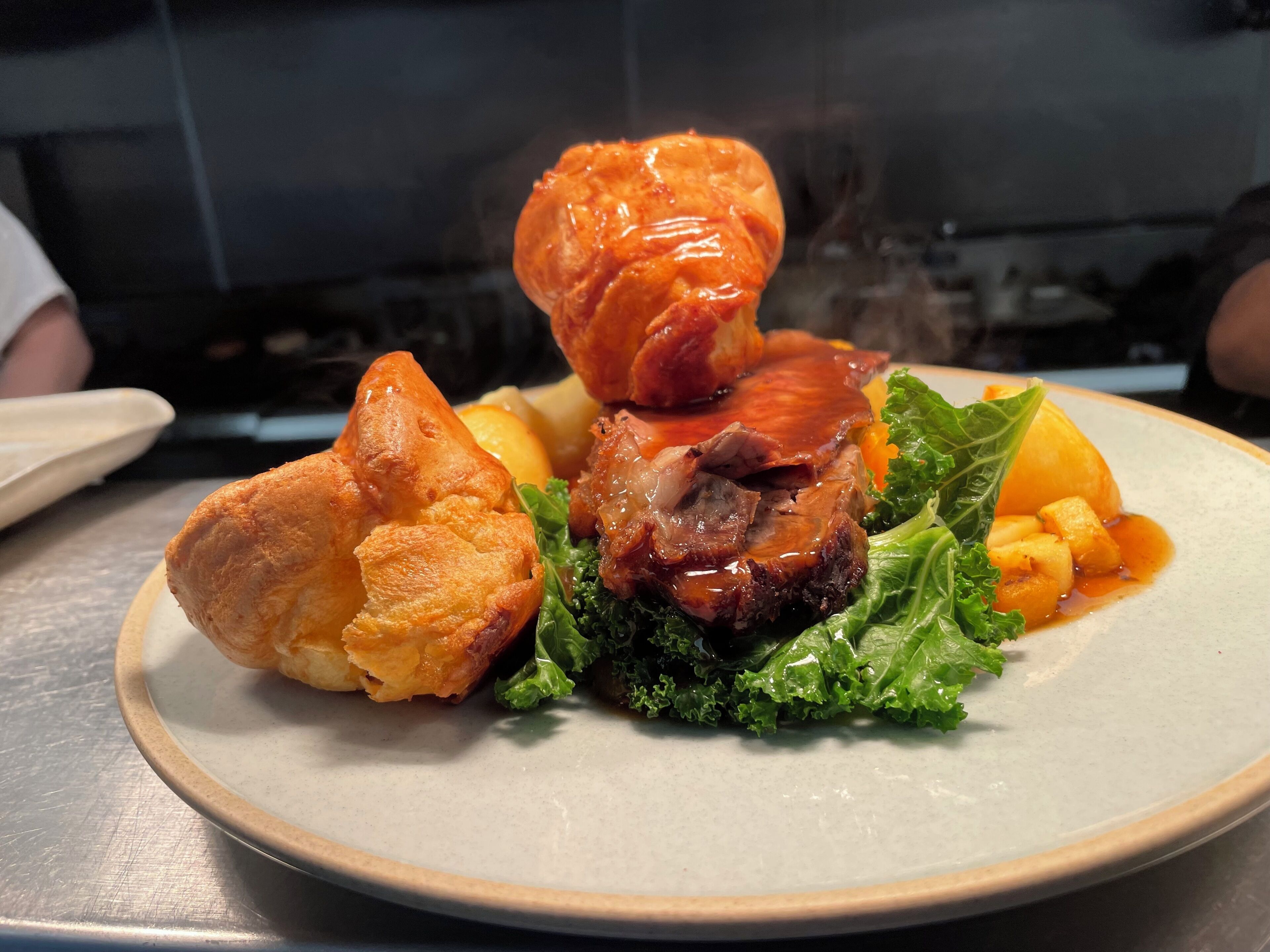 A plate with a roasted meat, a baked item, and some vegetables.