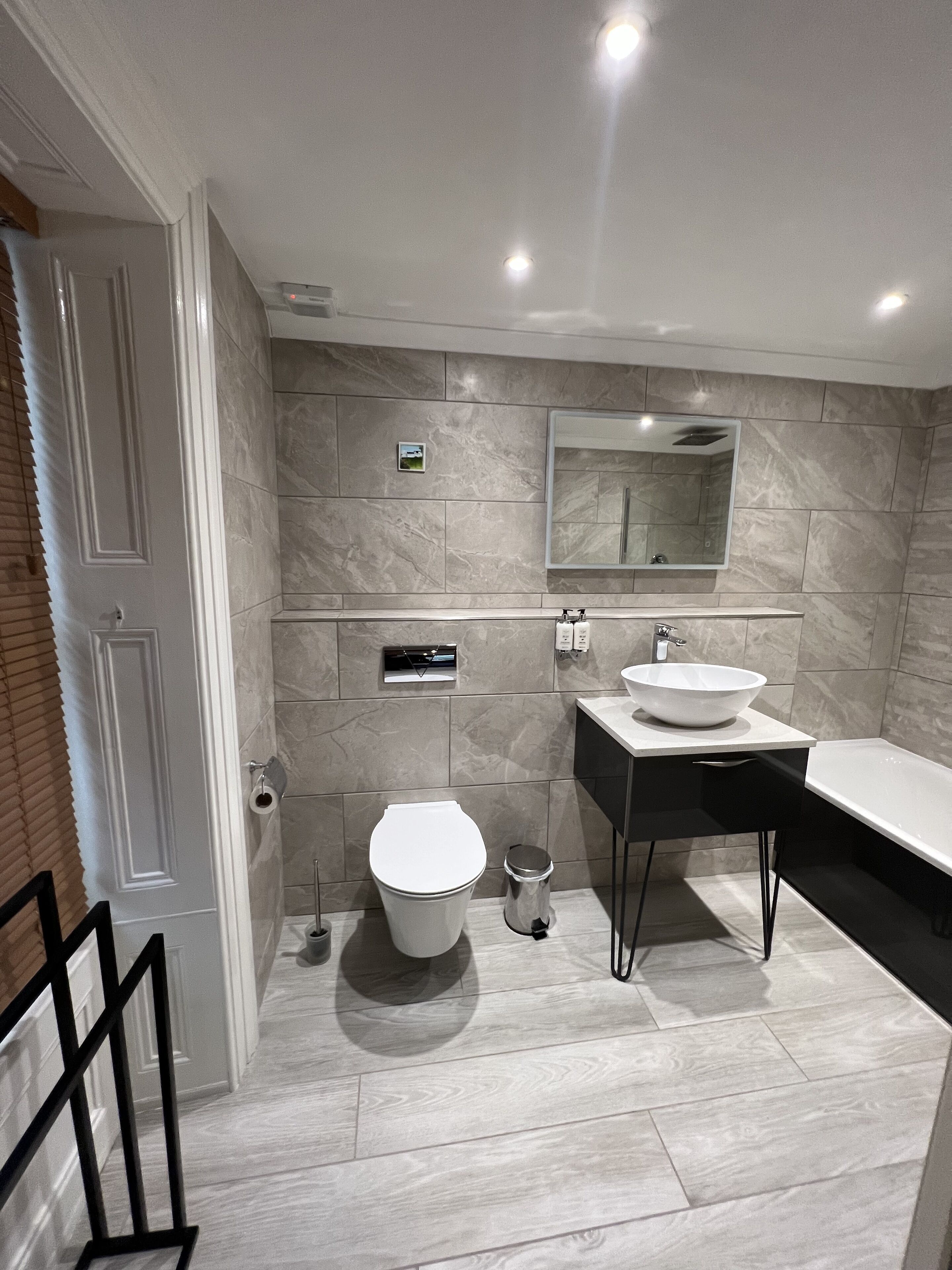 Un baño moderno con inodoro, lavamanos y bañera.