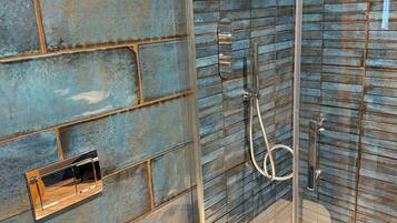 A bathroom with a glass shower enclosure, a wall-mounted towel rack, and a white sink.