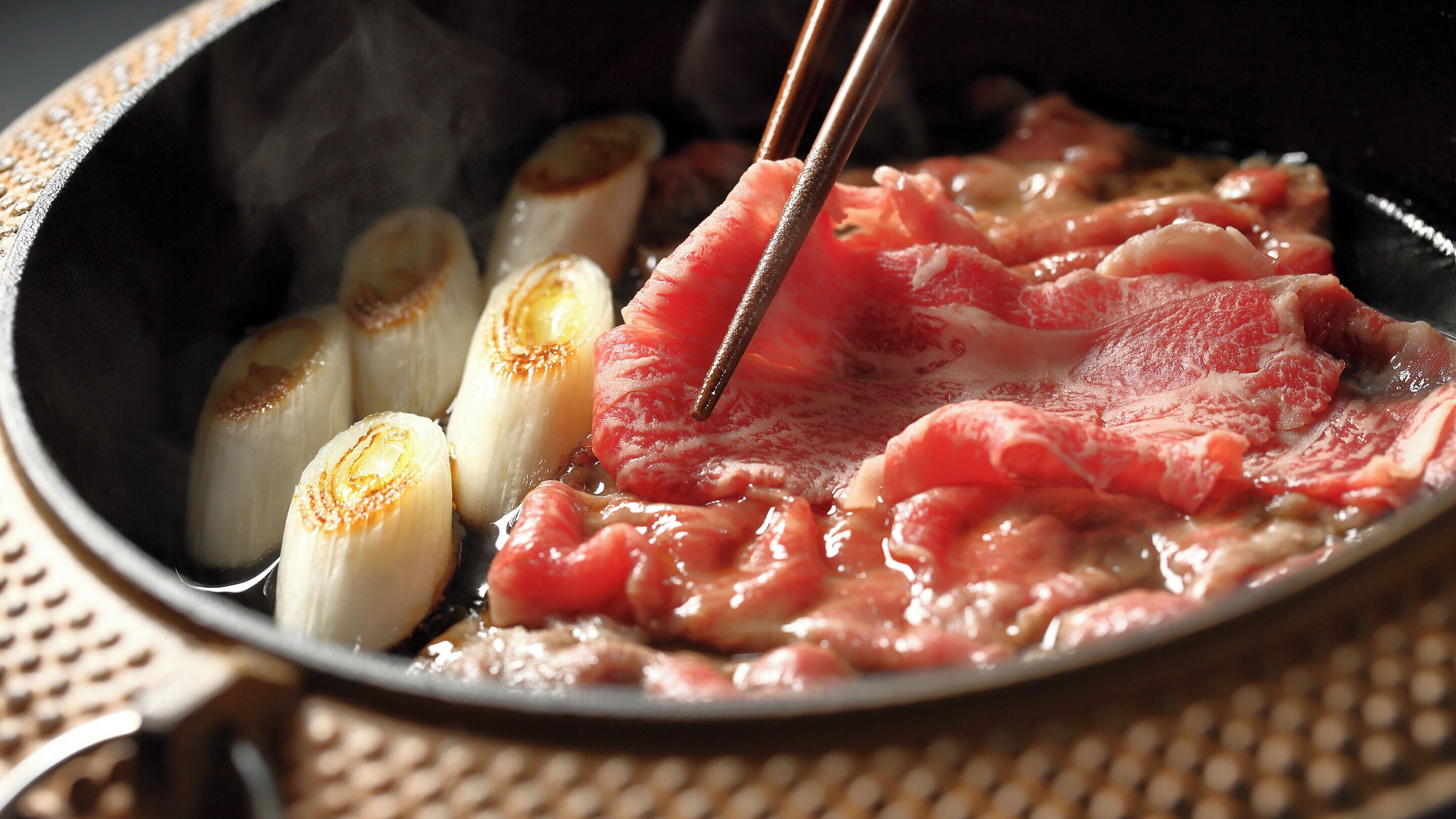 Une poêle contenant de la viande et des légumes grillés.