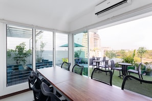A modern room with a large sliding glass door leading to an outdoor patio area. - H Hotels - Metro North Uno (Quezon City)