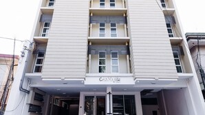A multi-story hotel with a central entrance, a flat facade, and a sign indicating it is a hotel. - H Hotels - Metro North Uno (Quezon City)