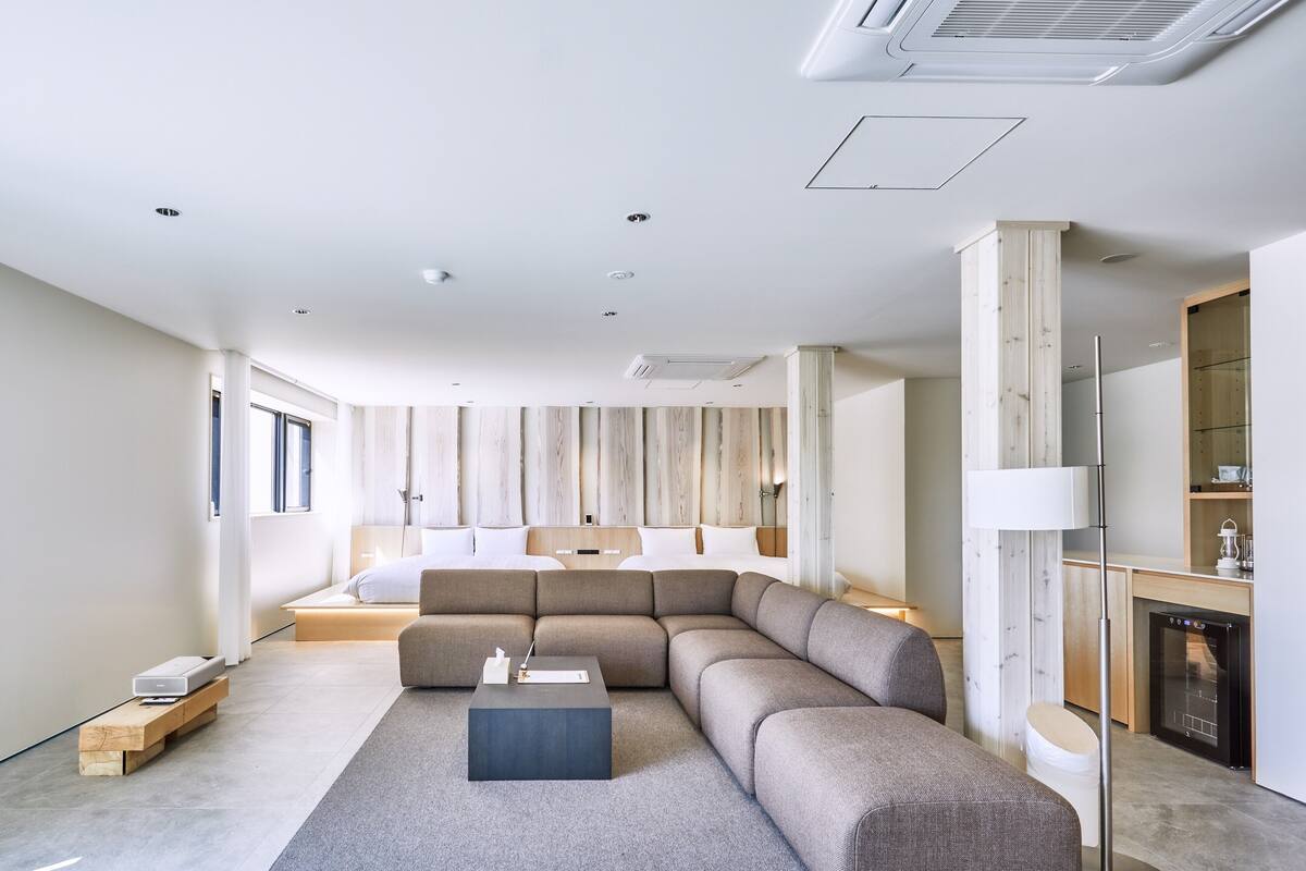 A modern living room with a sectional sofa, a coffee table, and a fireplace.