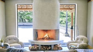 Una sala de estar moderna con chimenea de piedra, dos sofás y una mesa de centro.
