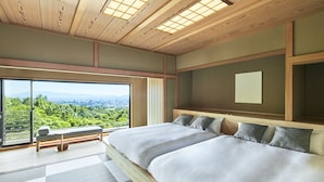 Un dormitorio moderno con una cama grande, un banco junto a la ventana y vistas a zonas verdes.